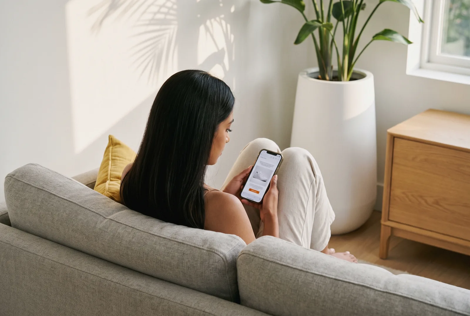 Woman reading a shopping email on her phone at home